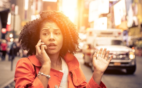 Woman on the phone after a car accident at sunset